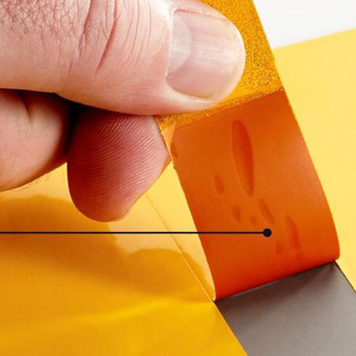 High-temperature polyimide masking tape being peeled off after a powder coating process.