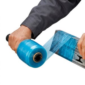 Worker using Krytape blue tinted hand stretch wrap with handle to secure metal industrial parts
